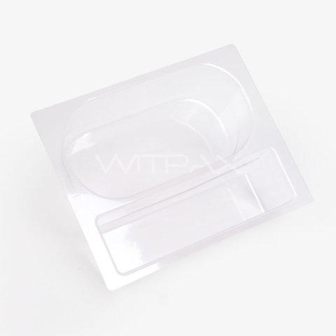 Clear thermoformed plastic box insert showing molded compartments from angled top view