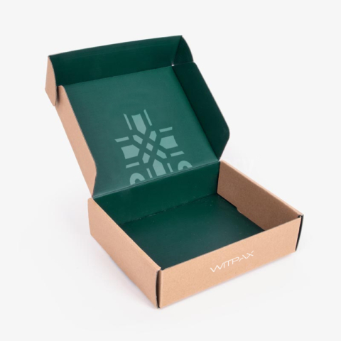 Open kraft brown mailer box showing green interior with geometric pattern printing