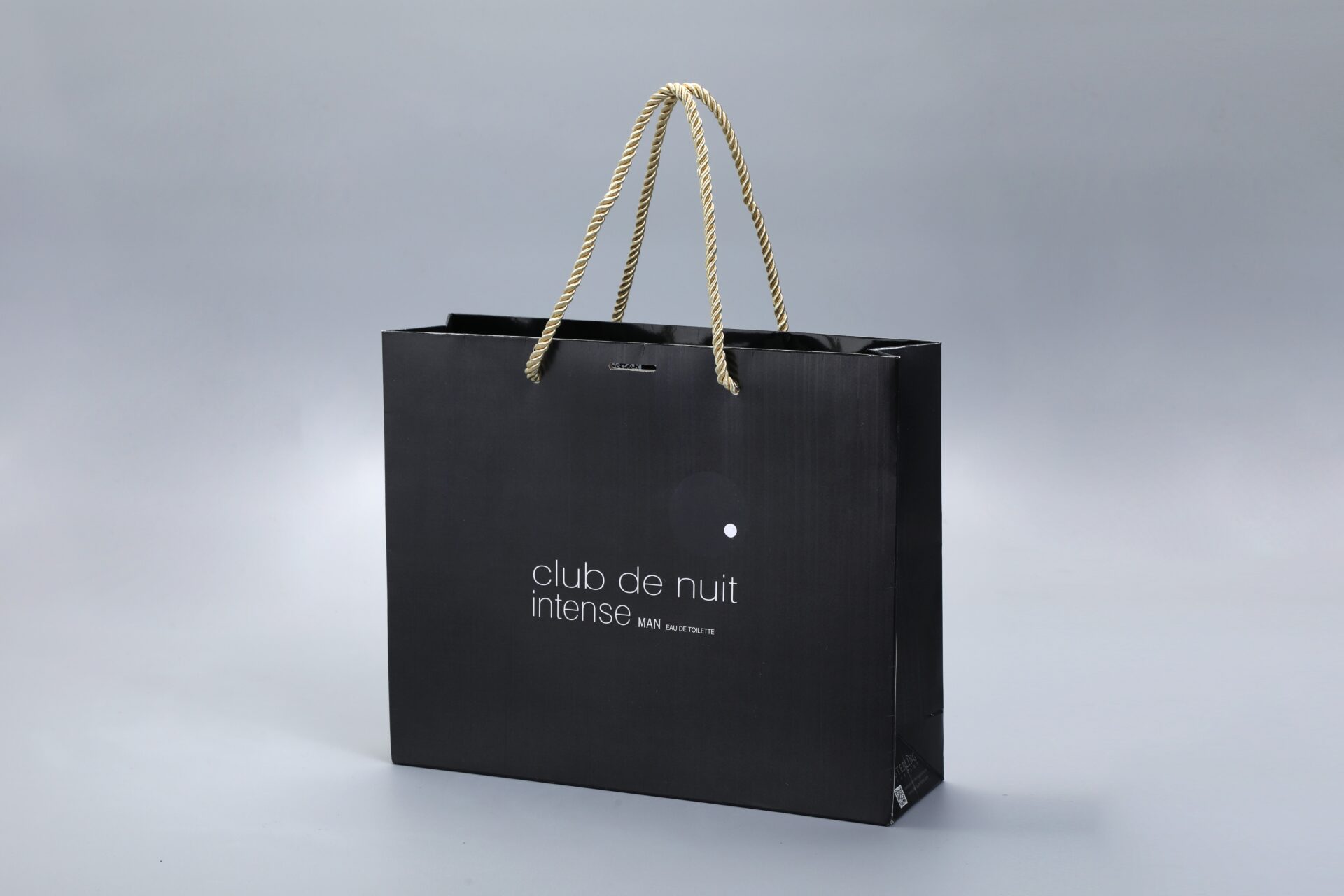 Our product is a custom black paper box with rope handles, designed with a minimalist gray background.