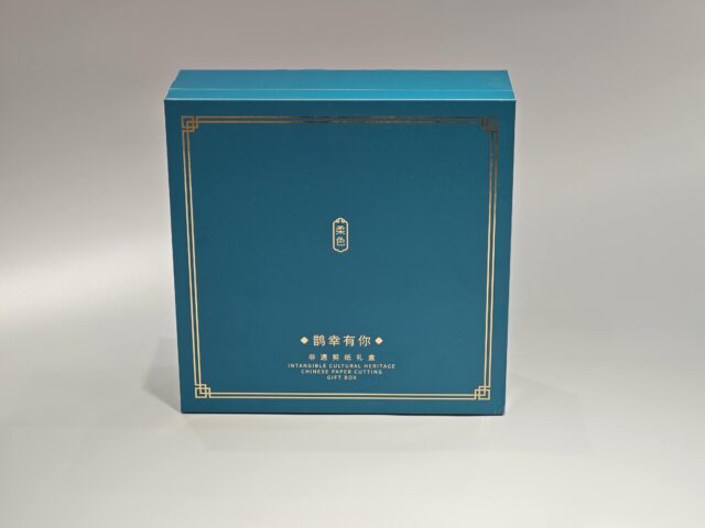 This image showcases our custom packaging solution: a blue gift box designed for cultural heritage items. It features elegant gold detailing and combines traditional and contemporary aesthetics, incorporating both English and Chinese elements.