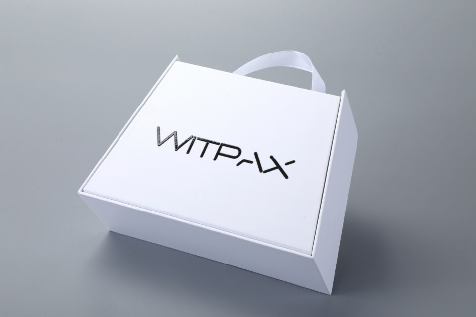 Trapezoidal book-style rigid box with straps