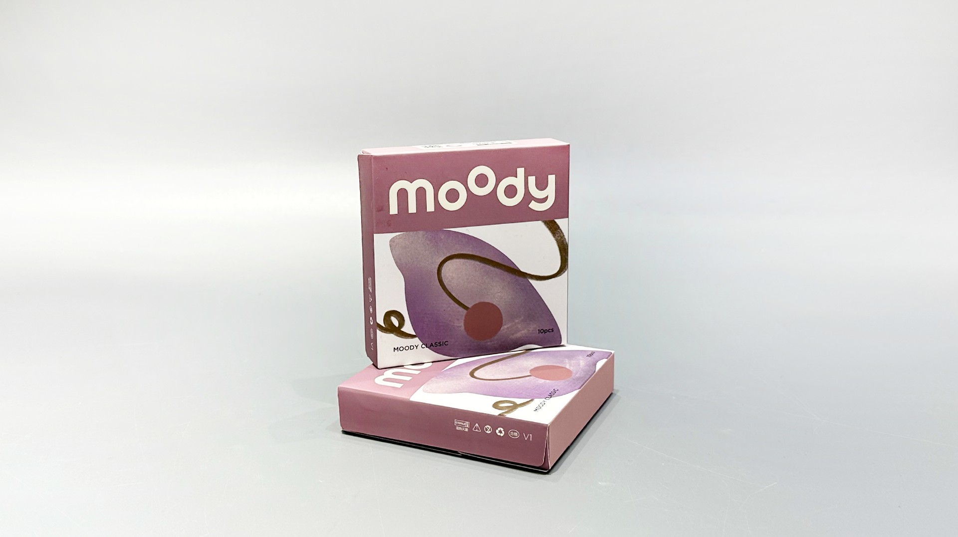 Two custom-designed pink folding cartons with abstract patterns are showcased against a plain background, harmonizing seamlessly with the brand's unique contact lens collection.