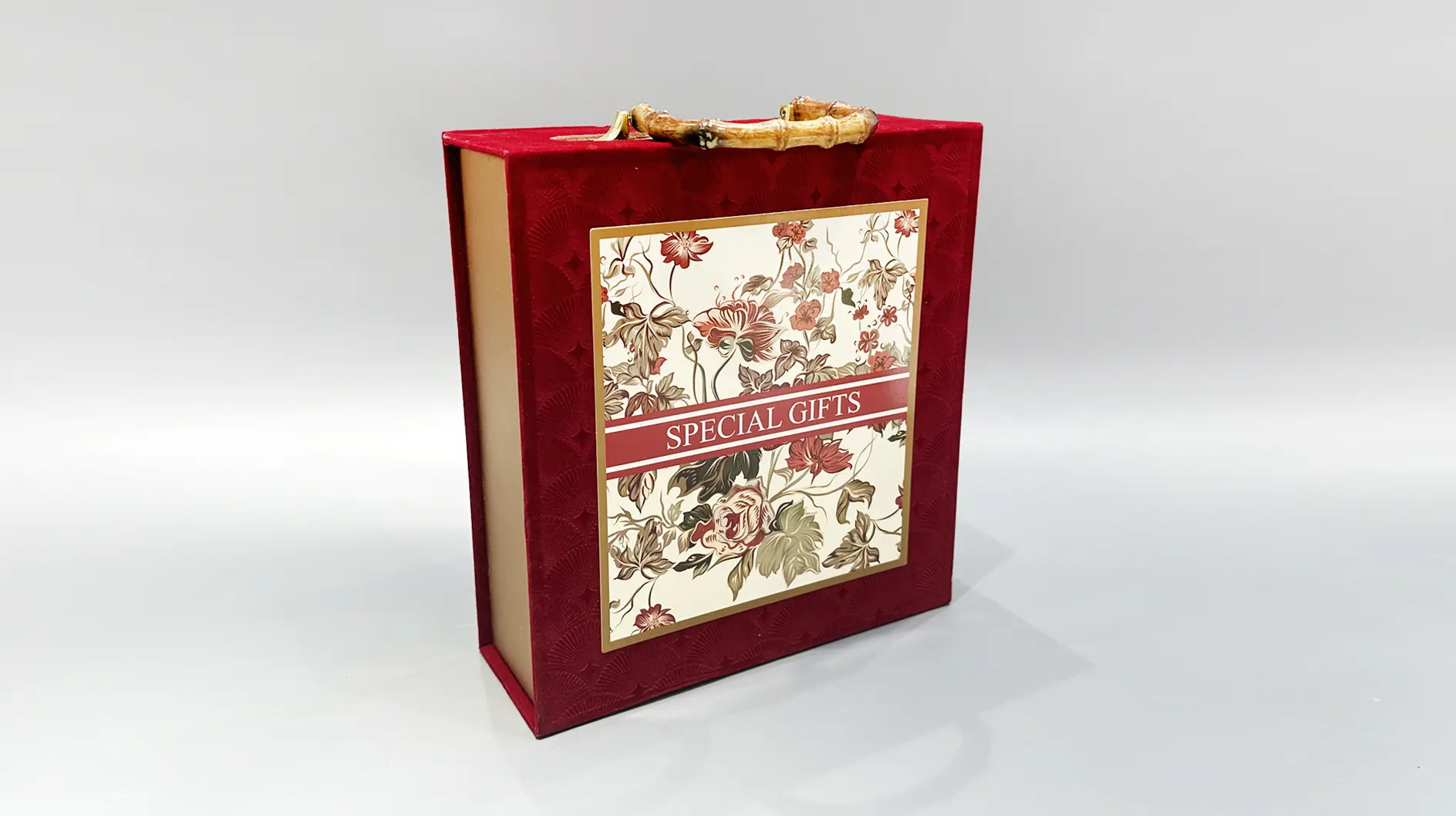We offer a beautifully designed red gift box adorned with an elegant floral pattern. Featuring bamboo-style handles, this packaging provides a charming and unique alternative to traditional gift boxes.