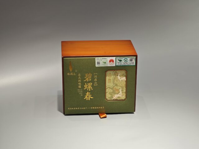 To update the description of your product in terms that align with packaging box terminology, let's revise it as follows:
"Our custom box packaging for green tea features a luxurious design, incorporating gold and white elements. The front of the package showcases elegant Chinese characters along with a detailed dragon illustration. Brand logos and quality stamps are prominently positioned in the top right corner to enhance brand recognition and authenticity."
This revision maintains focus on packaging design elements without explicitly mentioning any text on the packaging.